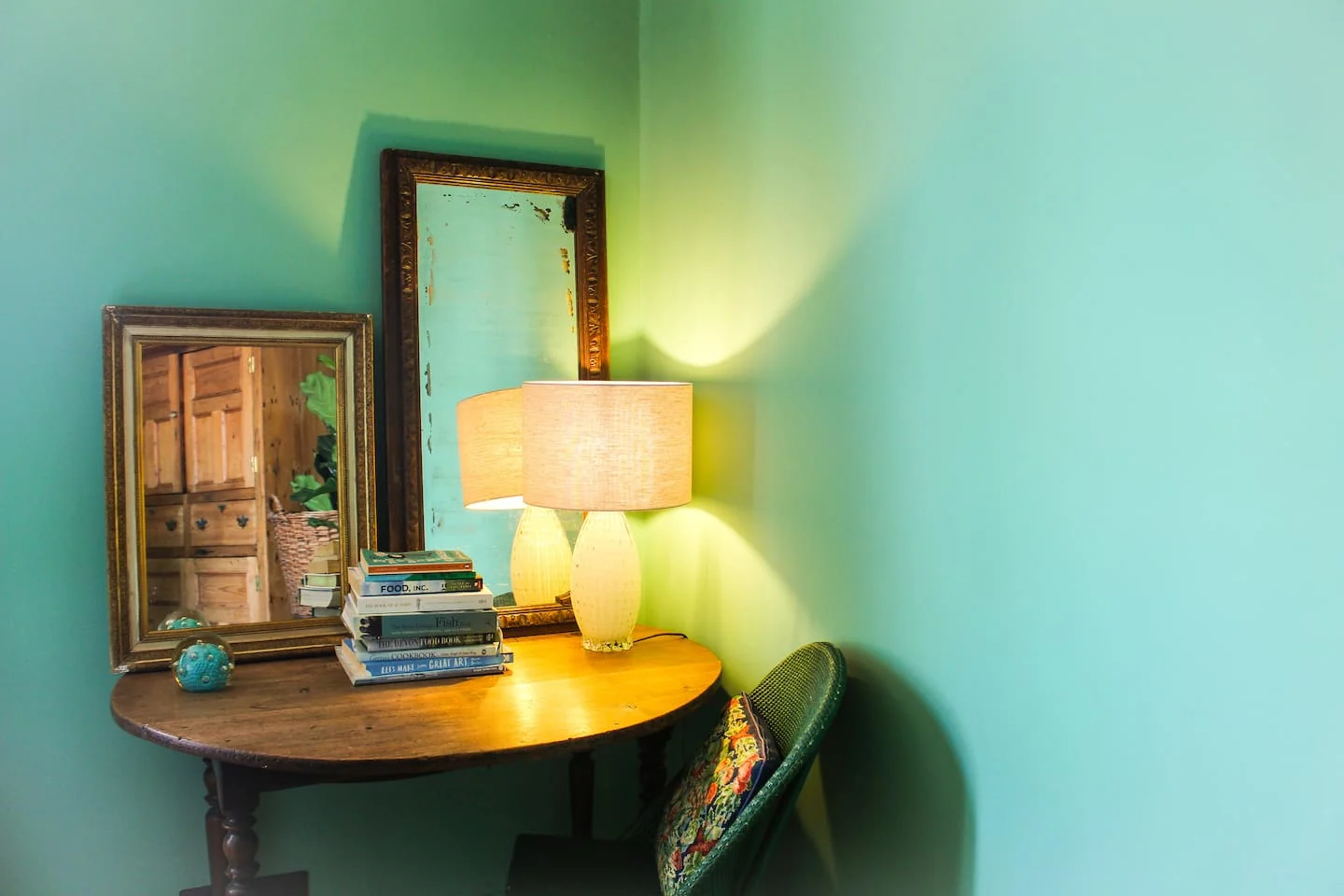 Small desk and mirror in a green-painted corner