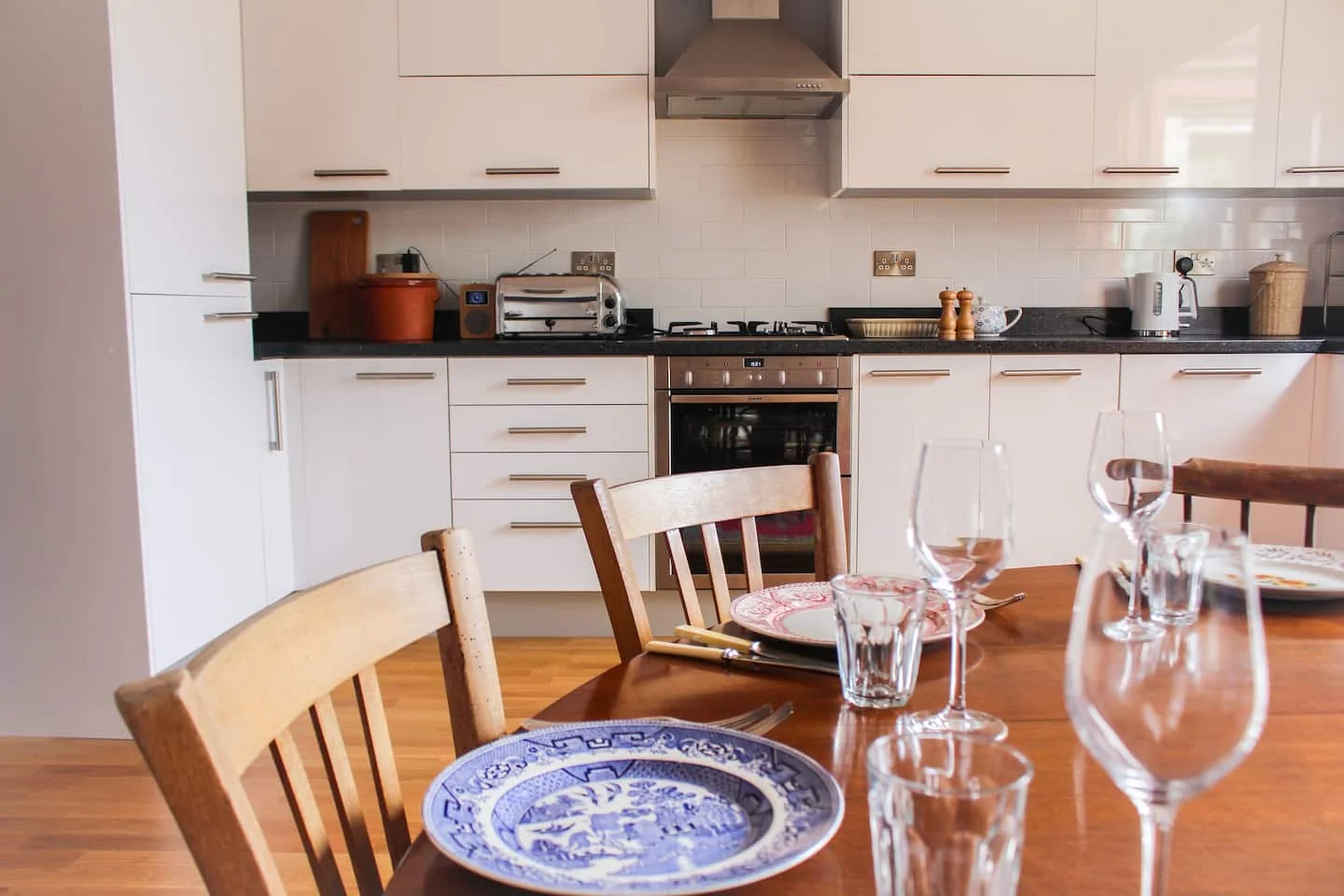 Table set with patterned plates beside the apartment kitchen