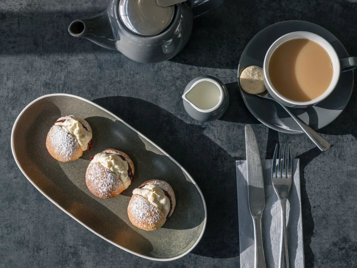 Devon splits with cream served beside a cup of tea
