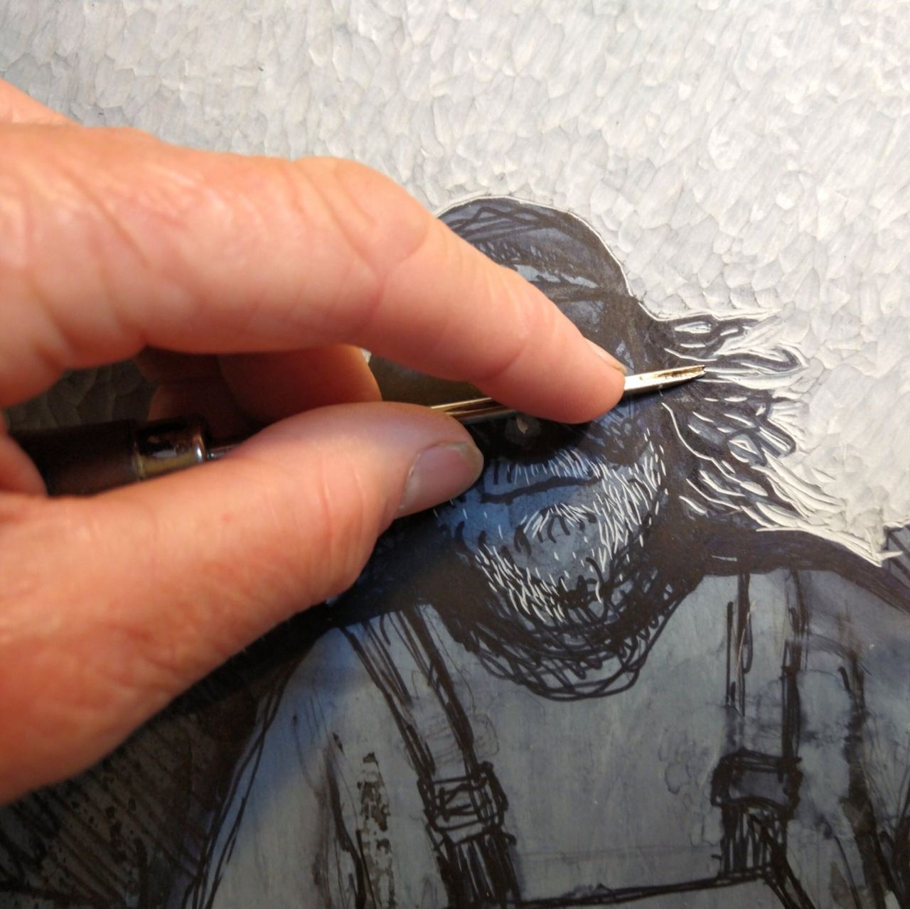 A person carving a detailed printing block