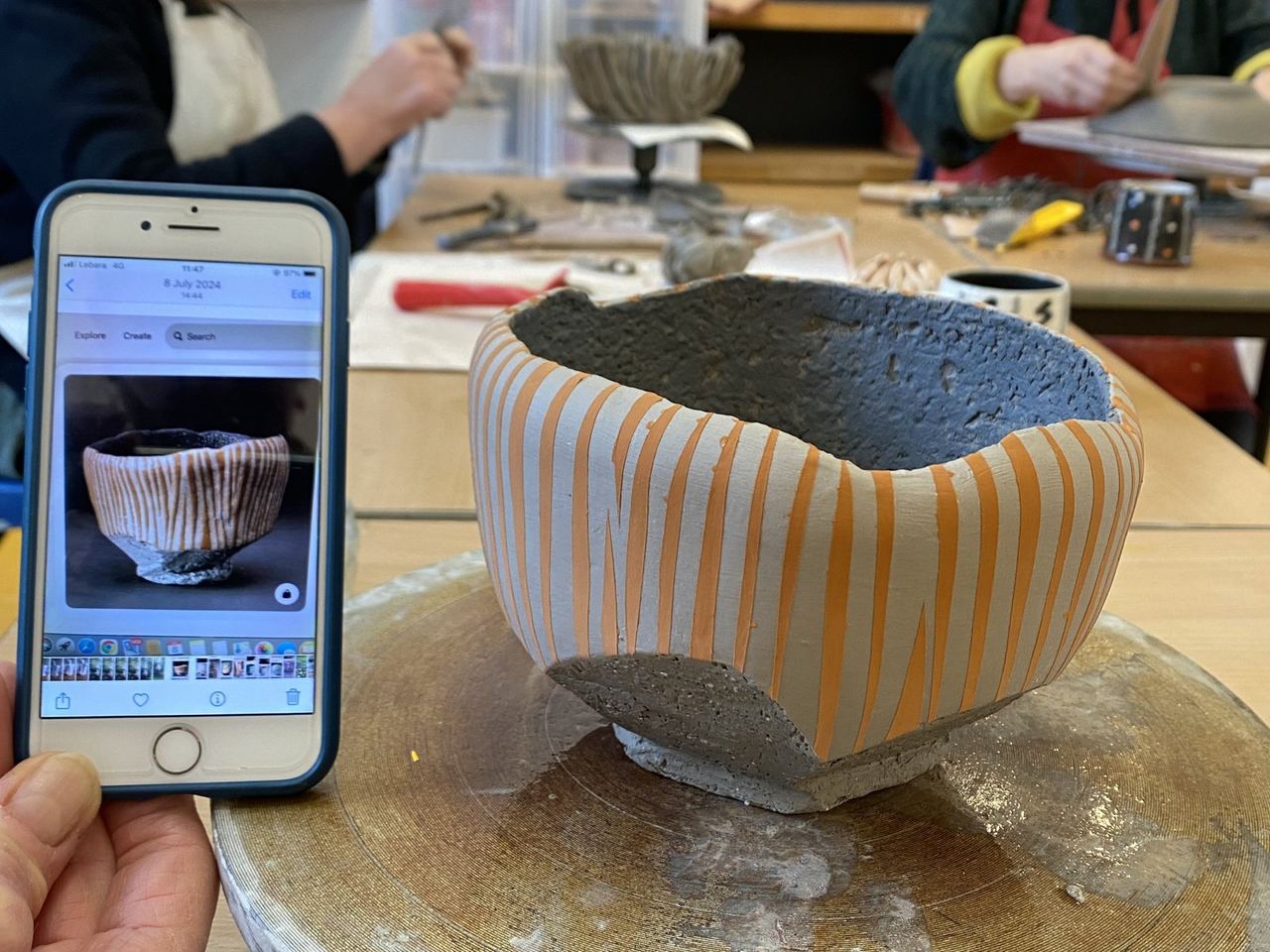 A striped clay vessel taking shape during an Art House workshop