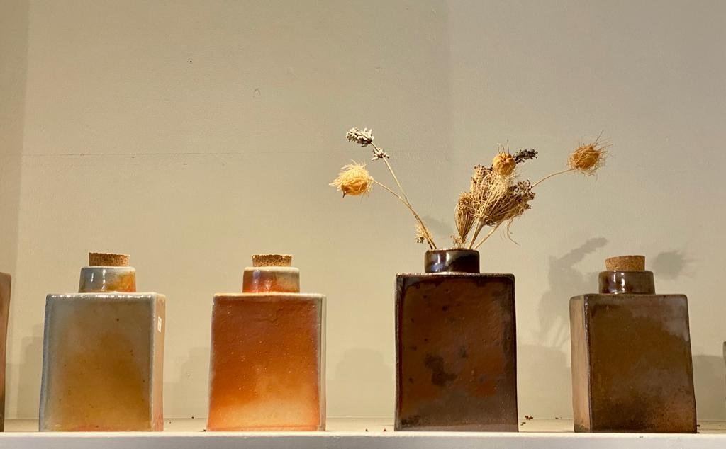 Warm glazed ceramic vases displayed with dried flowers