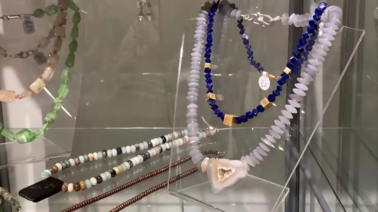 Handmade necklaces displayed in a glass case at Artworks