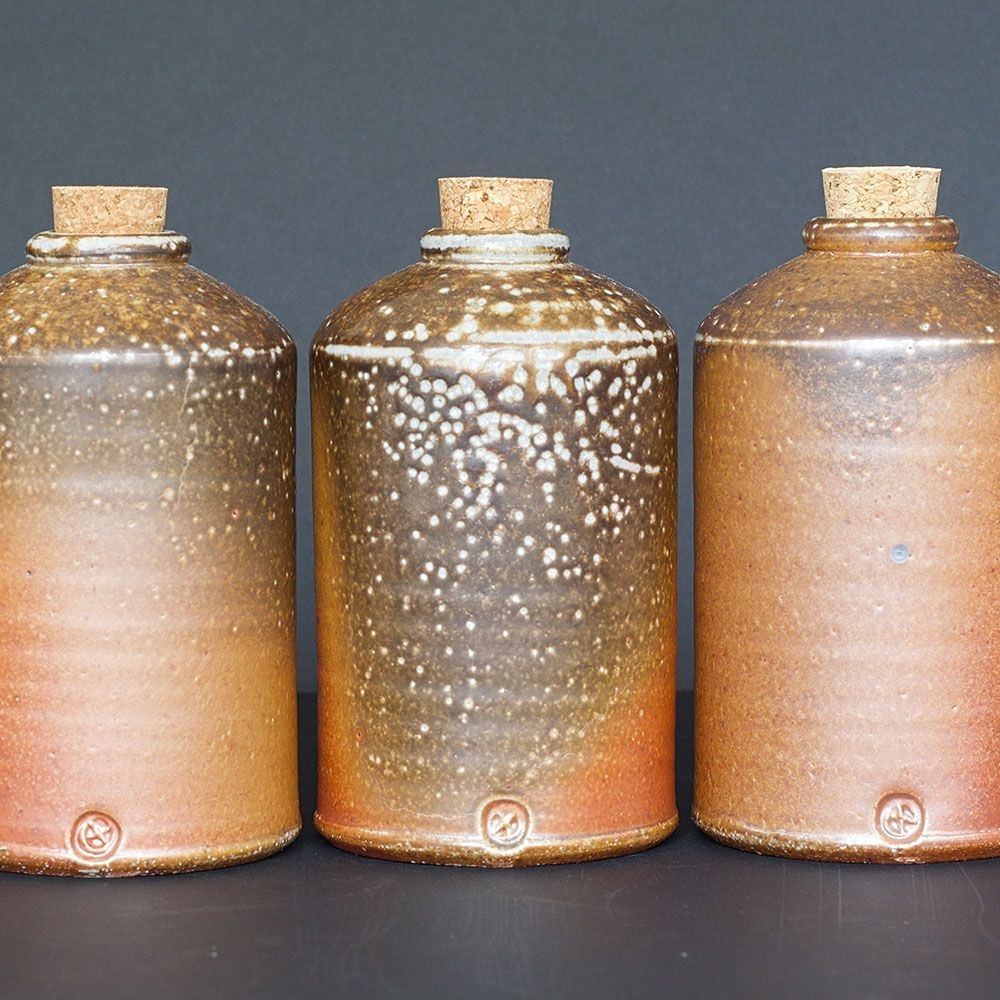 Three handmade ceramic bottles in earthy colours