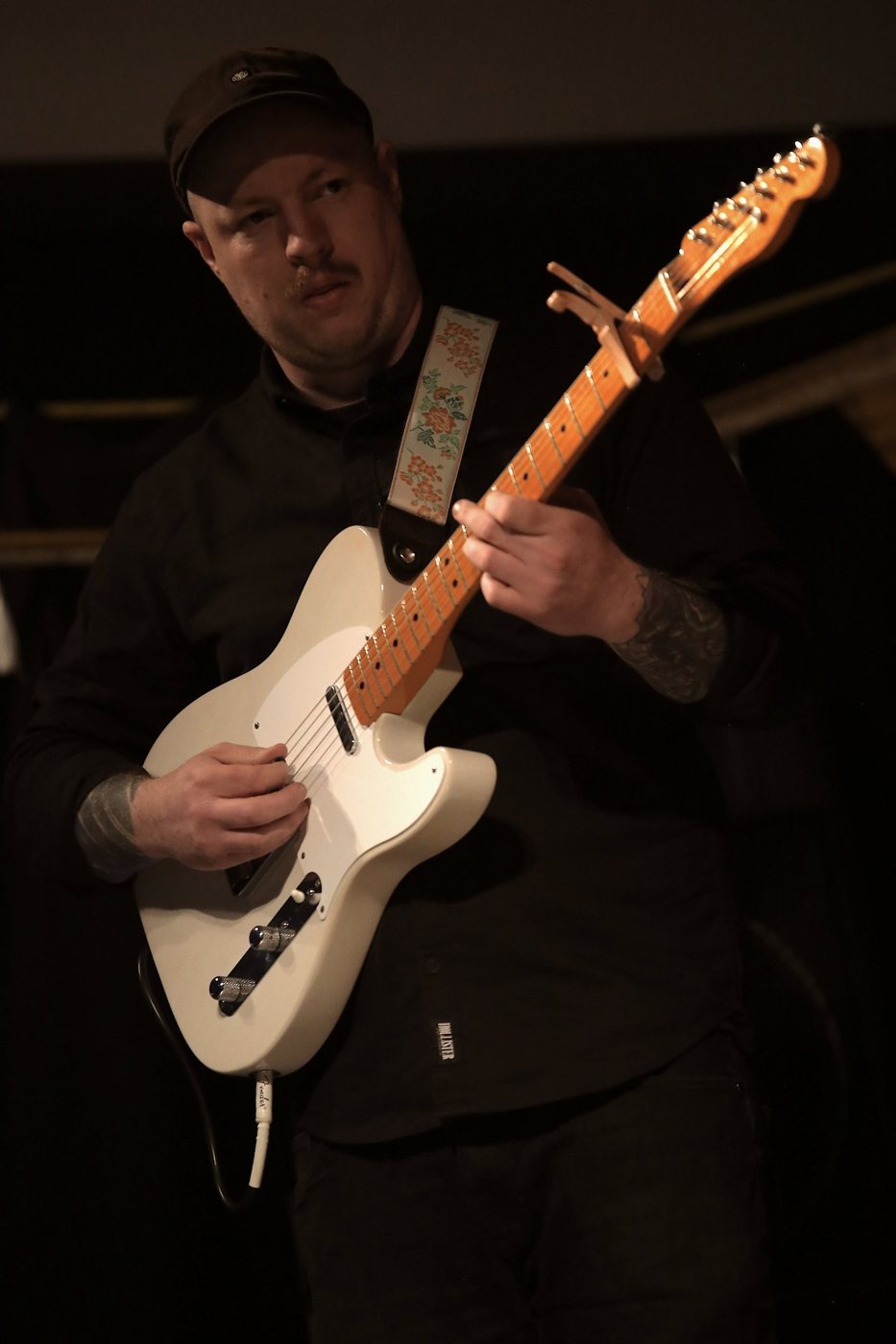 Electric guitarist Lee Croad performing under warm lighting