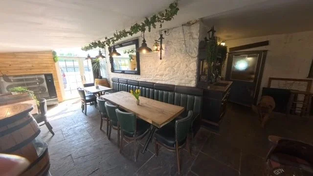 Warmly lit Lounge dining room with wooden tables at the Avon Inn