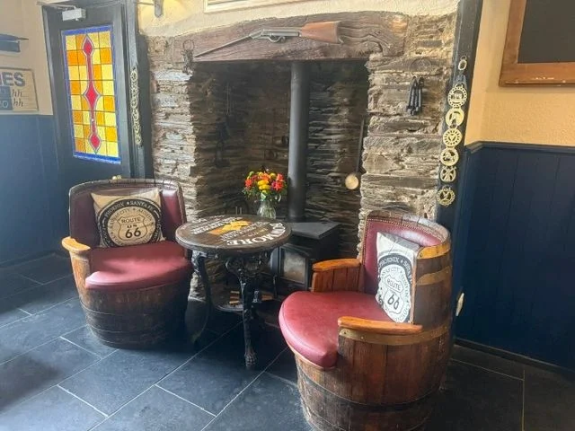 Stone fireplace and upholstered chairs at the Avon Inn