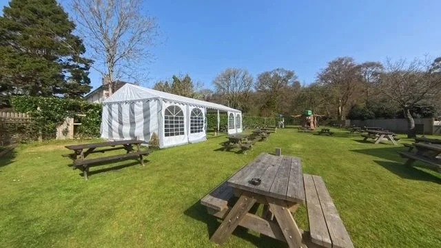 Picnic tables and a marquee in the Avon Inn garden