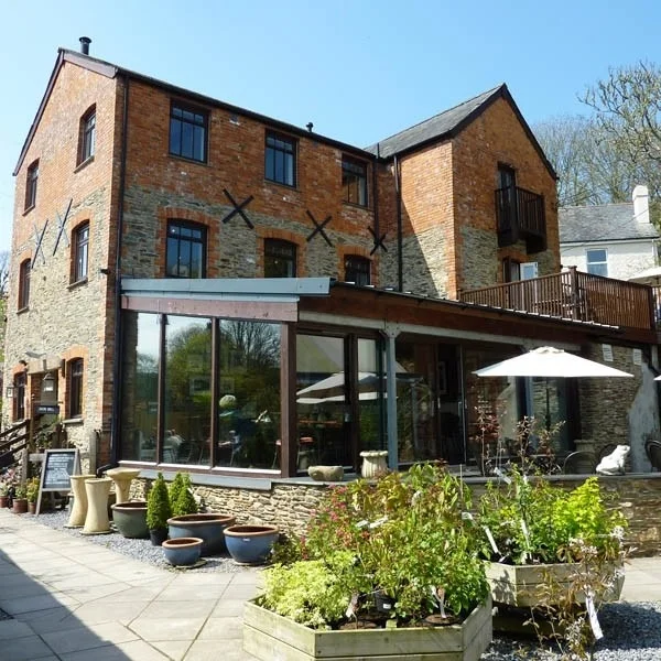 Brick mill building and café terrace surrounded by plants
