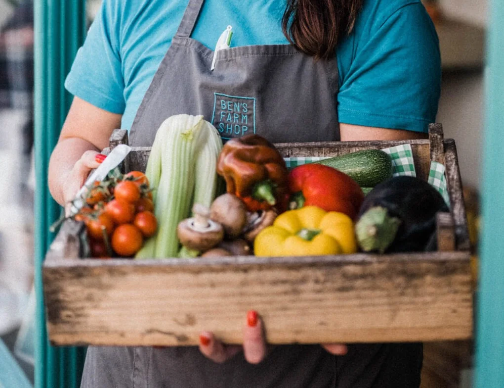 A member of the Ben’s team holding a crate of vegetables