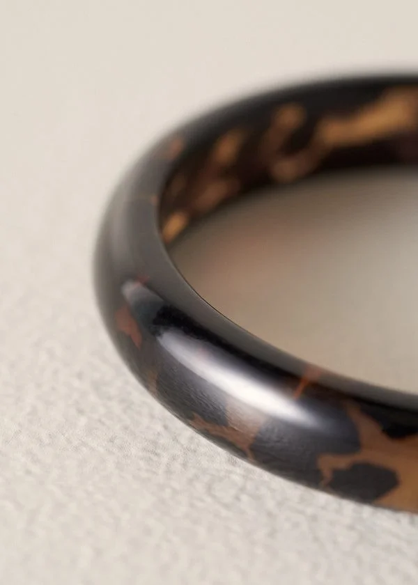 Close-up of a patterned resin bangle by Busby & Fox