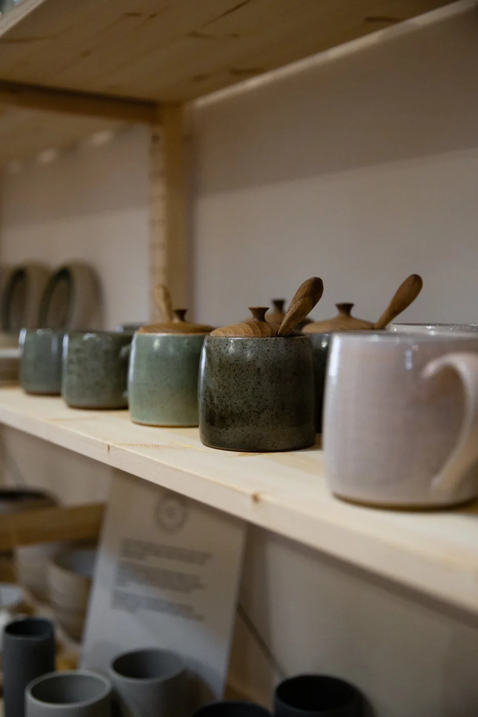 Glazed mugs lined up on Butterwalk’s shelves