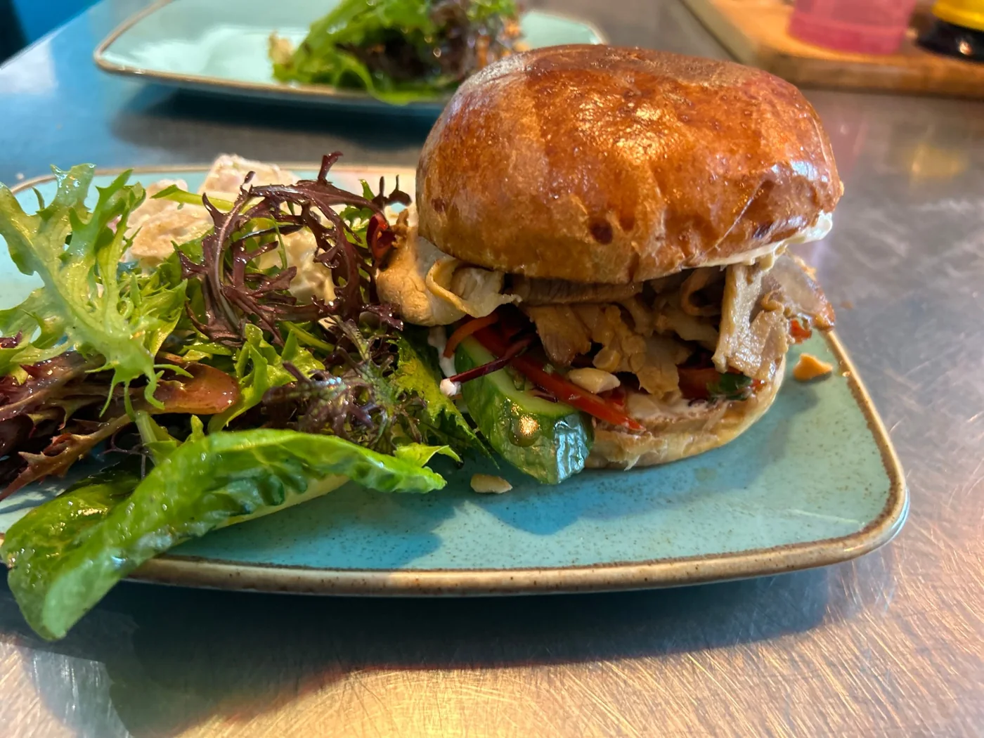 A filled brioche bun and salad at Canteen
