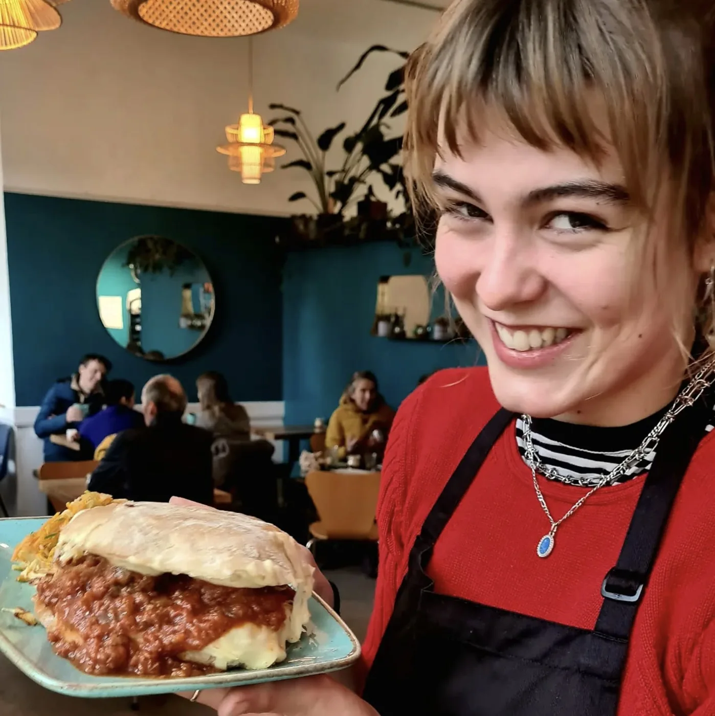 A member of the Canteen team holding a filled bun