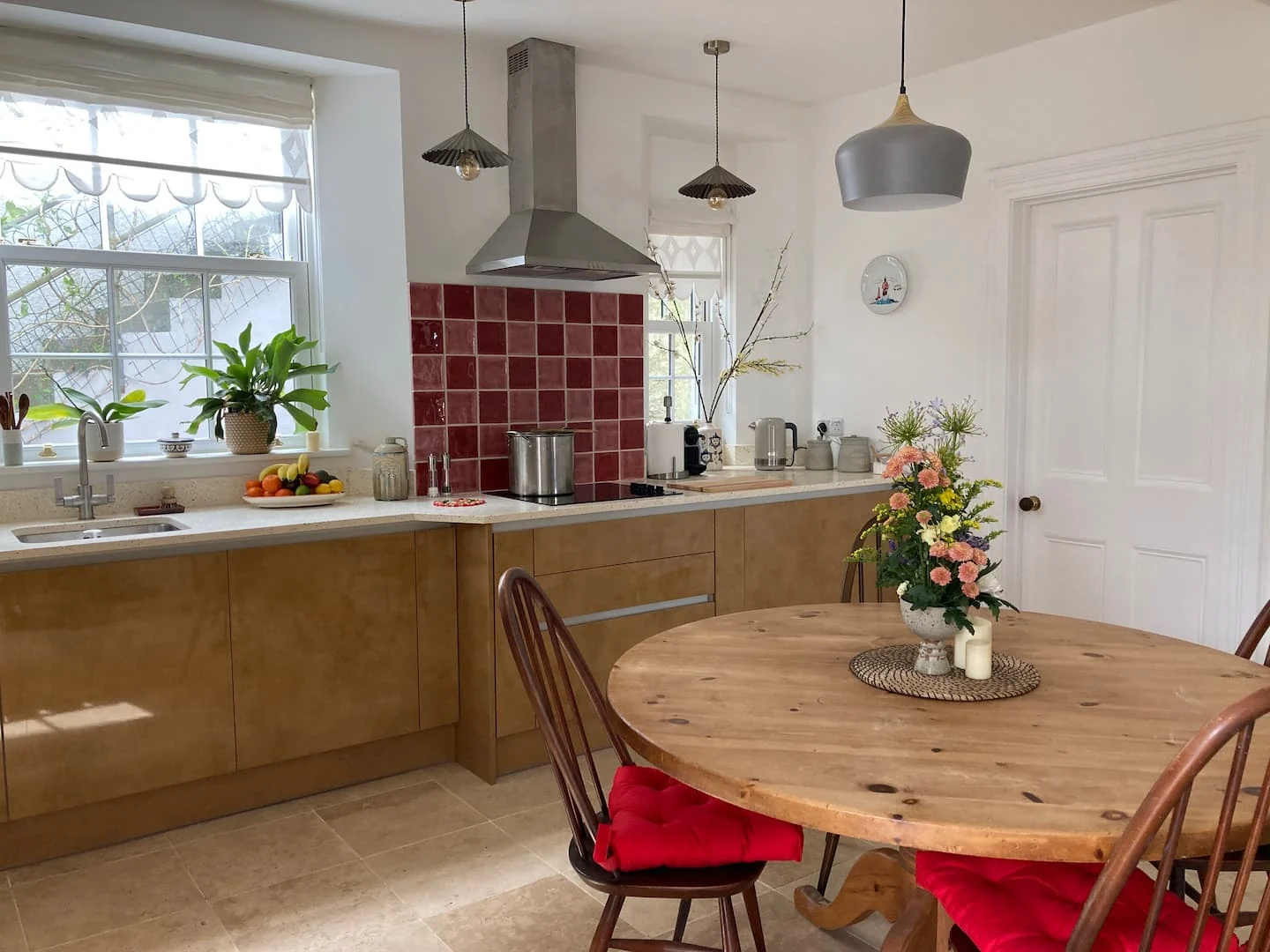 Wooden kitchen and round dining table with red chairs