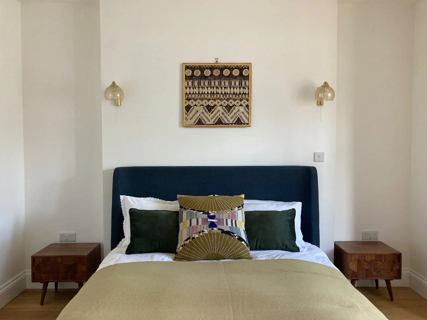 Bedroom with dark upholstered headboard and green bedding