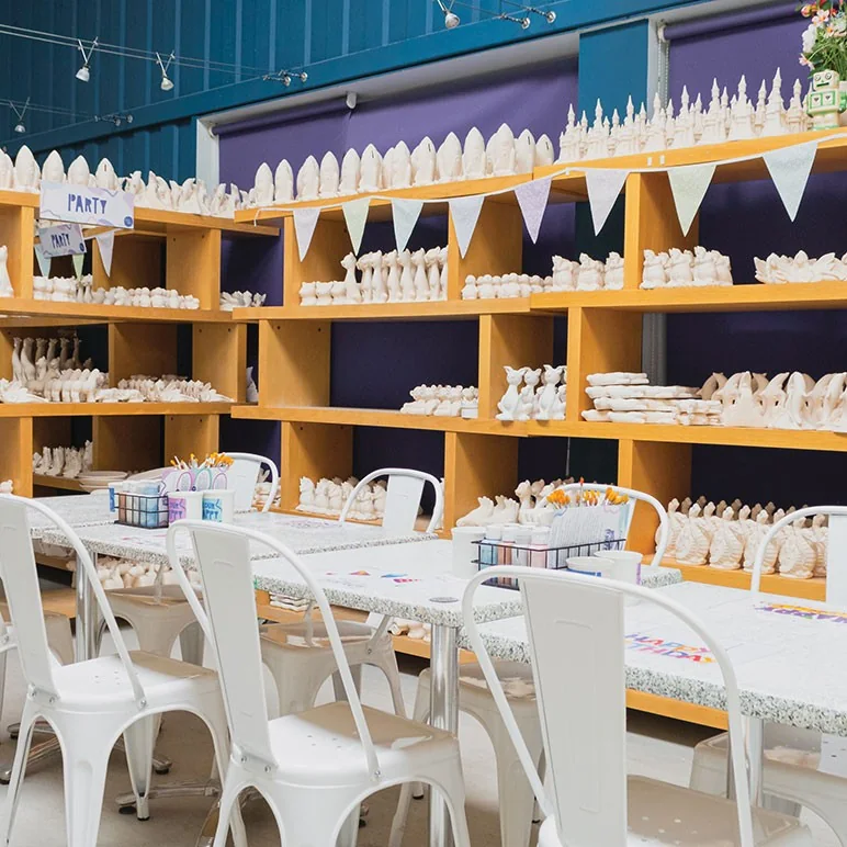 Tables and shelves of unpainted pottery in China Blue’s studio