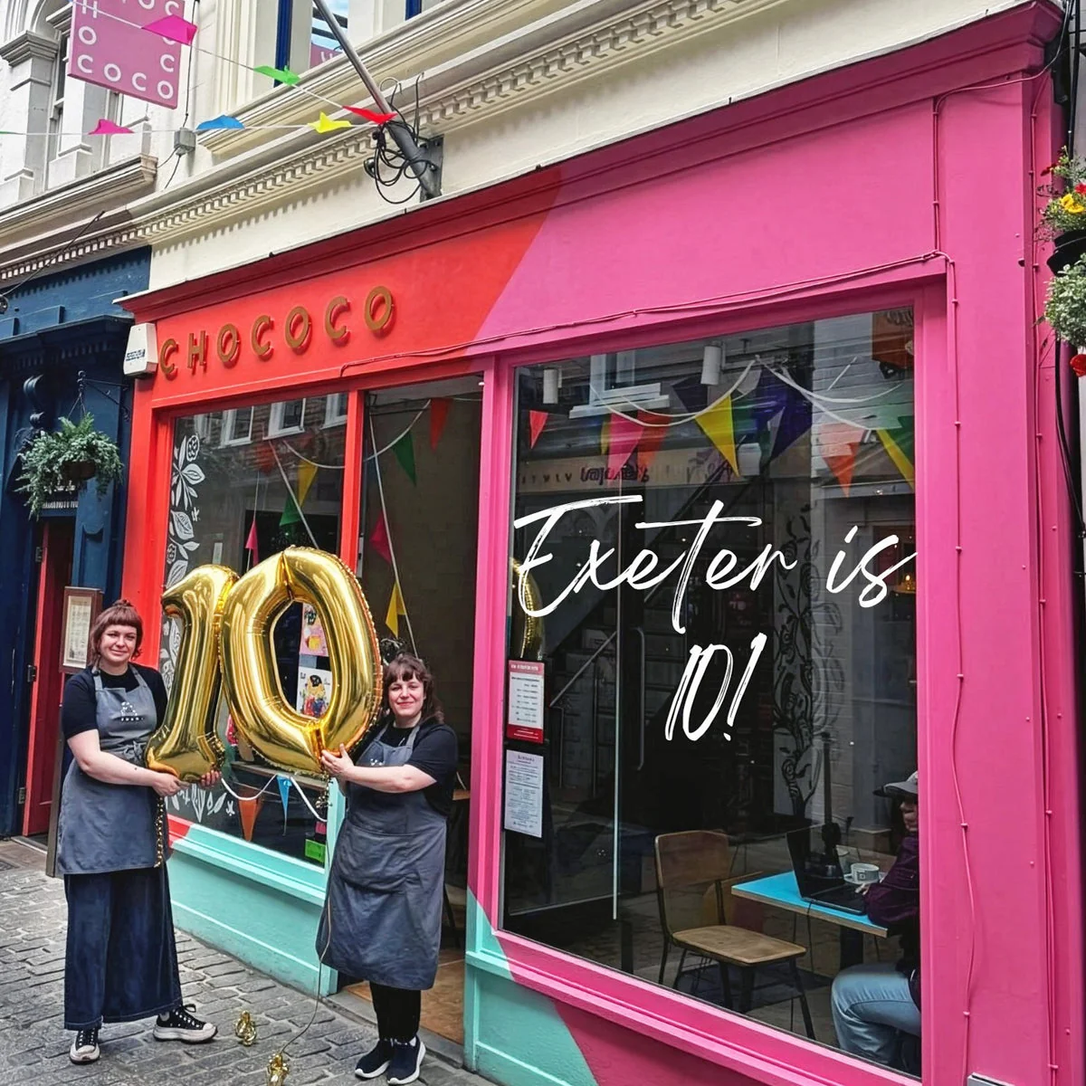 Team members outside Chococo Exeter’s pink shopfront with tenth-birthday balloons
