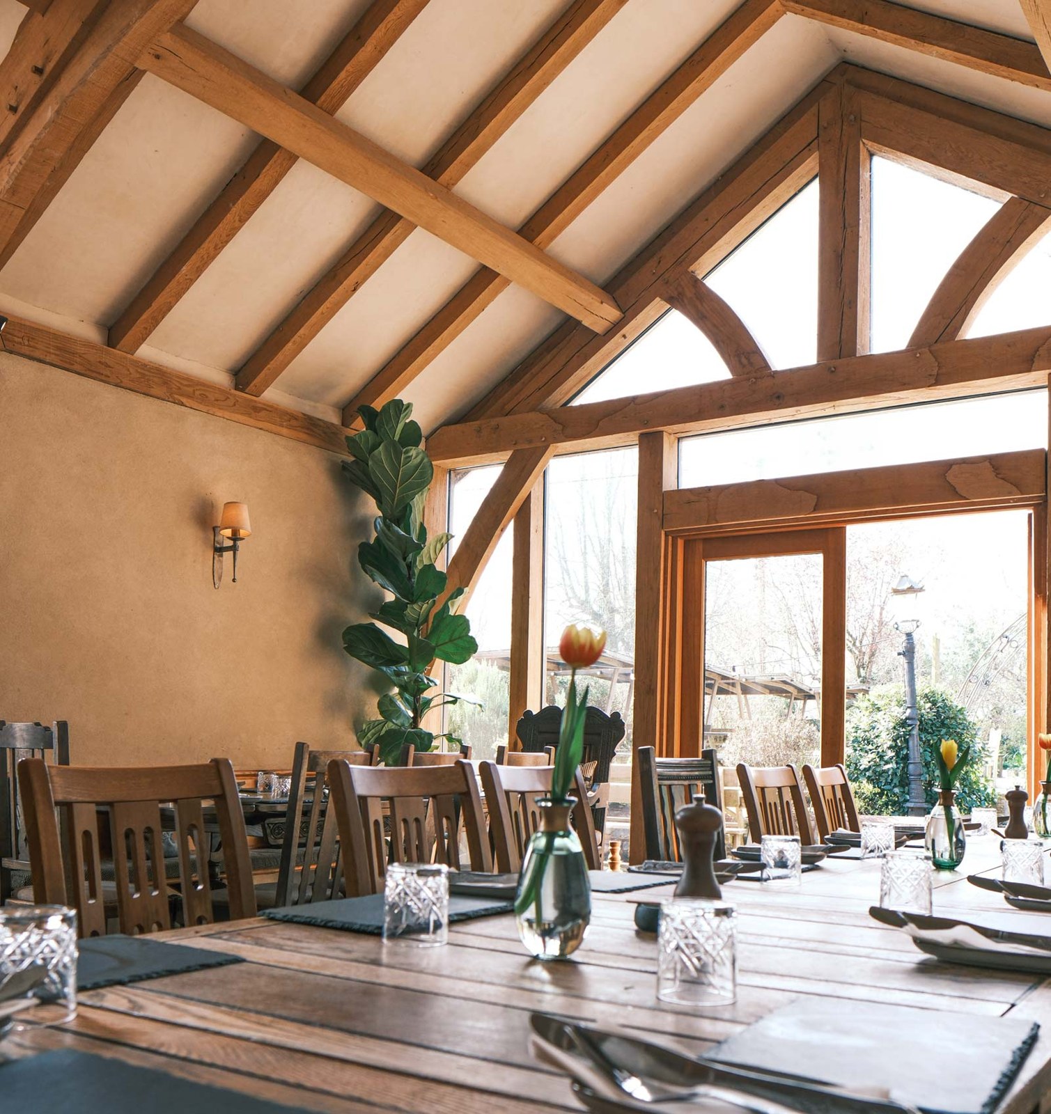 Sunlit oak-framed dining room with set tables at The Church House Inn