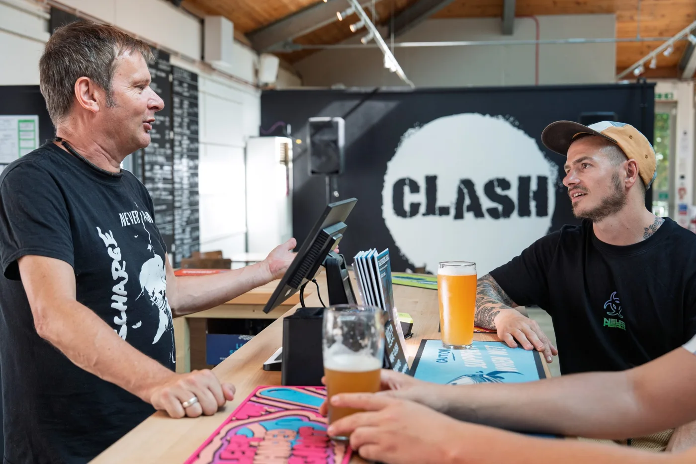 Guests talking across the colourful bar at CLASH Taproom