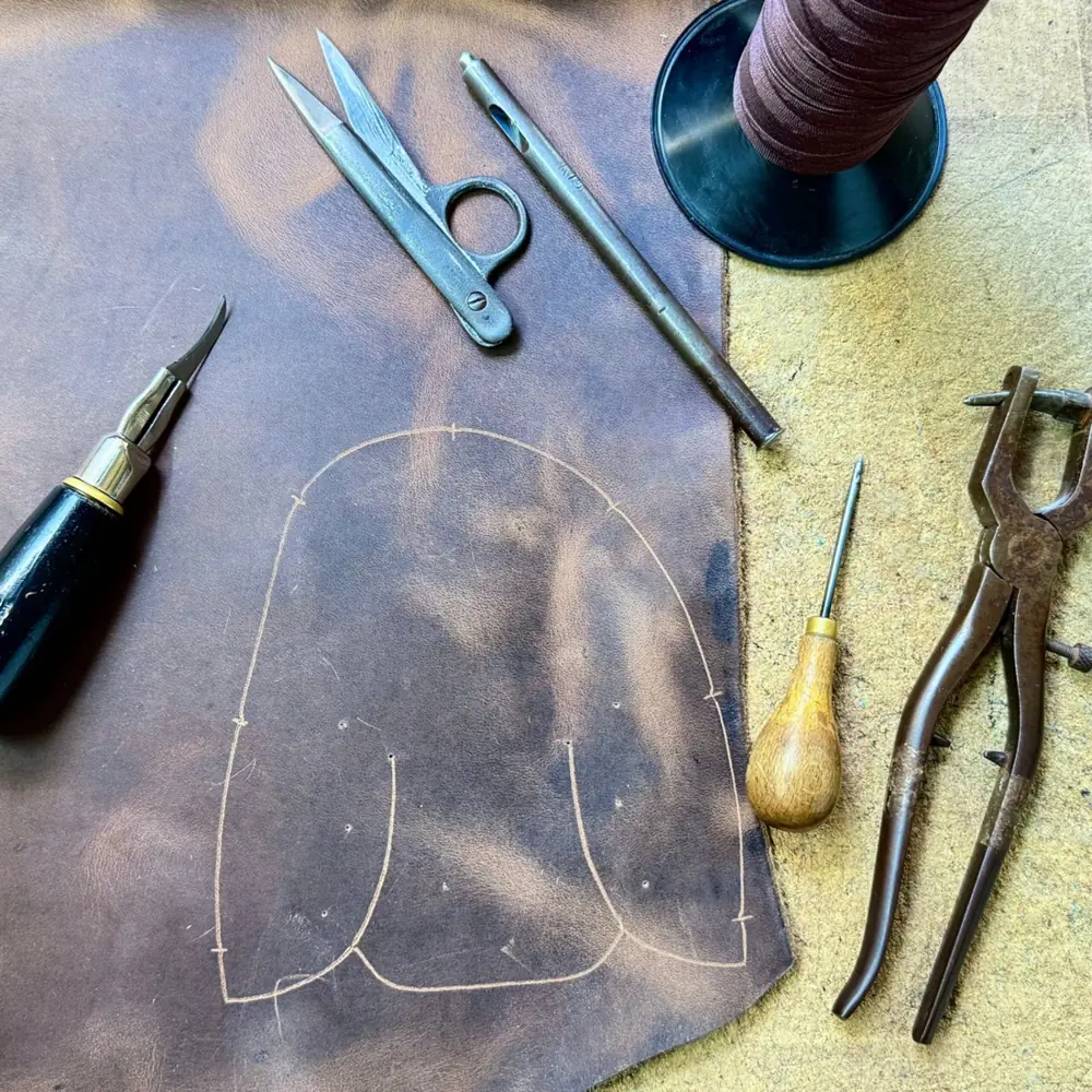Leather, tools and thread on a Conker shoemaking workbench