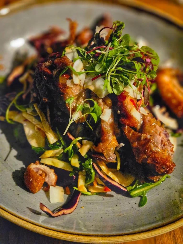 A plated dish topped with fresh herbs and greens at The Coombe Cellars