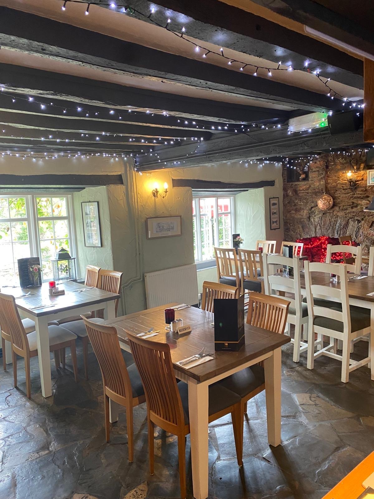 Wooden dining tables in a beamed room at Court Farm Inn