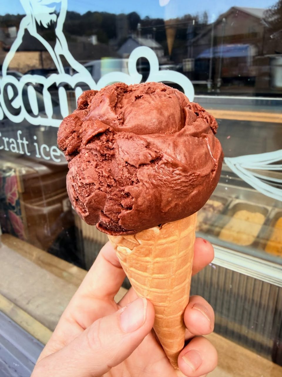 A chocolate ice cream scoop in a waffle cone outside Creamo’s in Ashburton