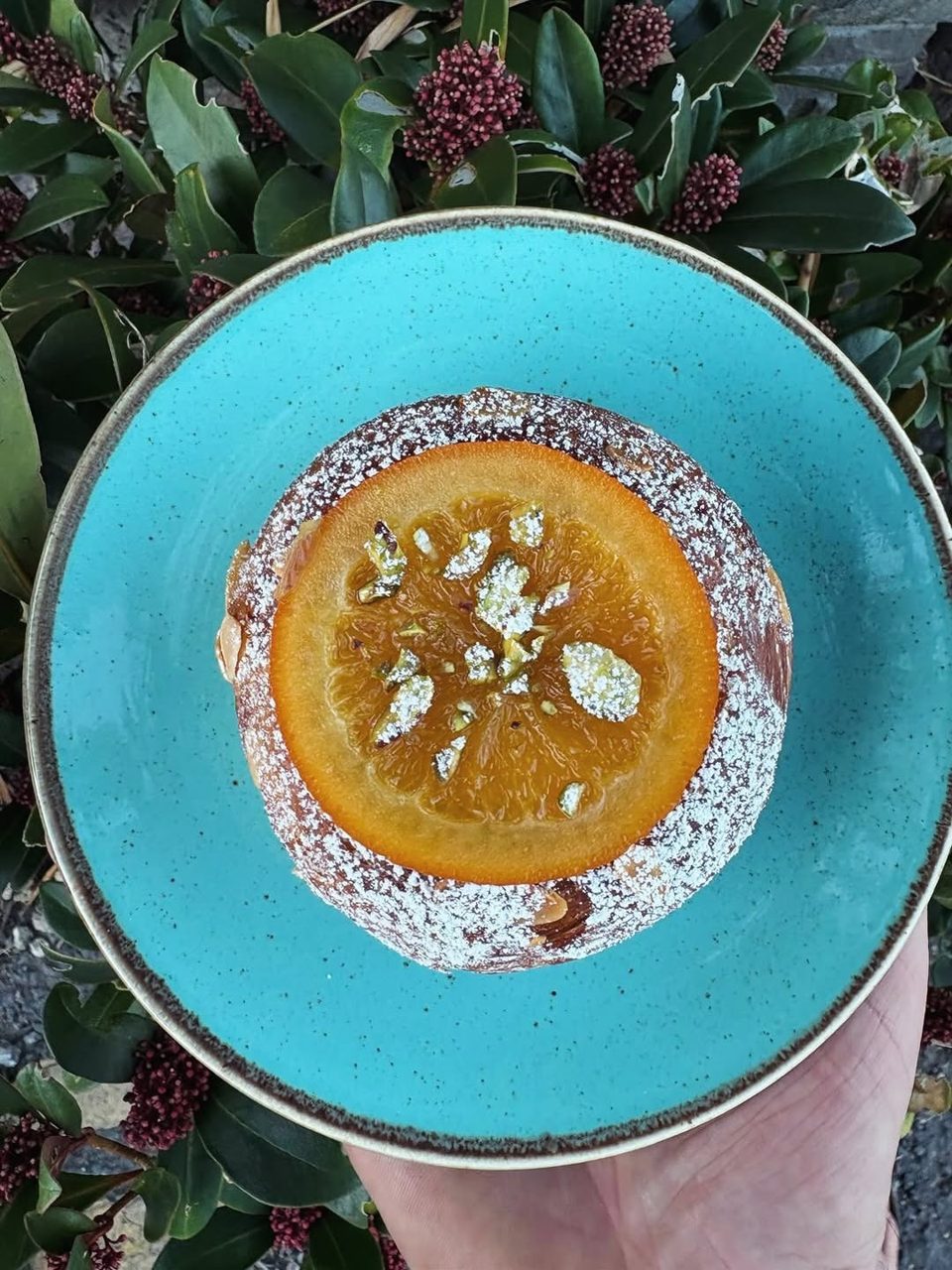 An orange-topped Danish pastry on a turquoise plate