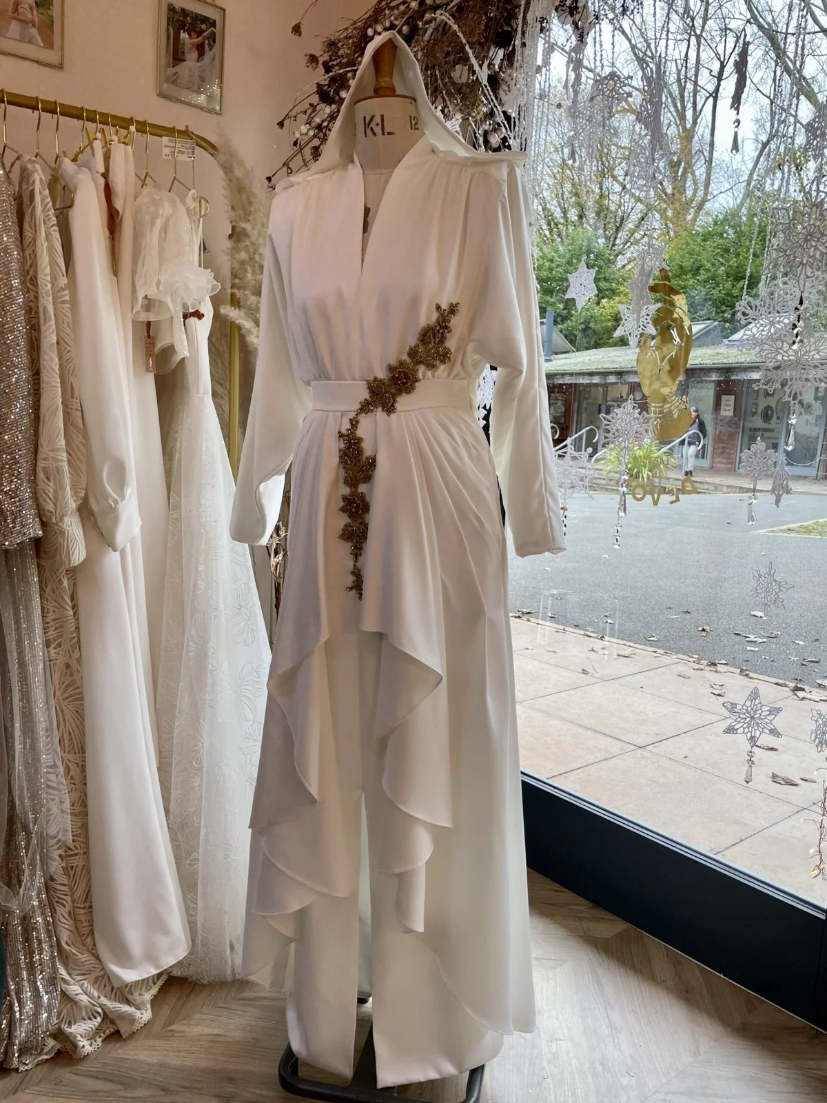 Pale bridal gown displayed beside the studio window