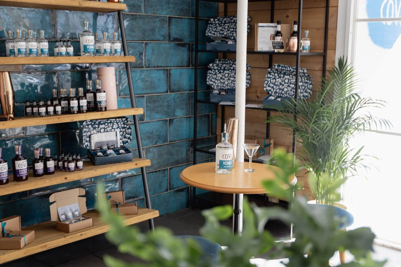 Bottles and gift boxes on shelves inside Devon Cove’s Kingsbridge Tasting Room