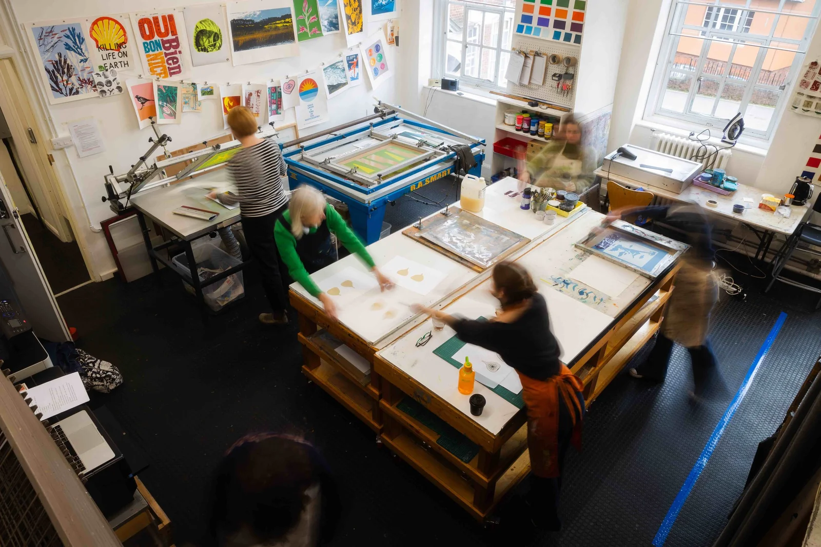People working at a large table in Double Elephant’s screenprinting studio