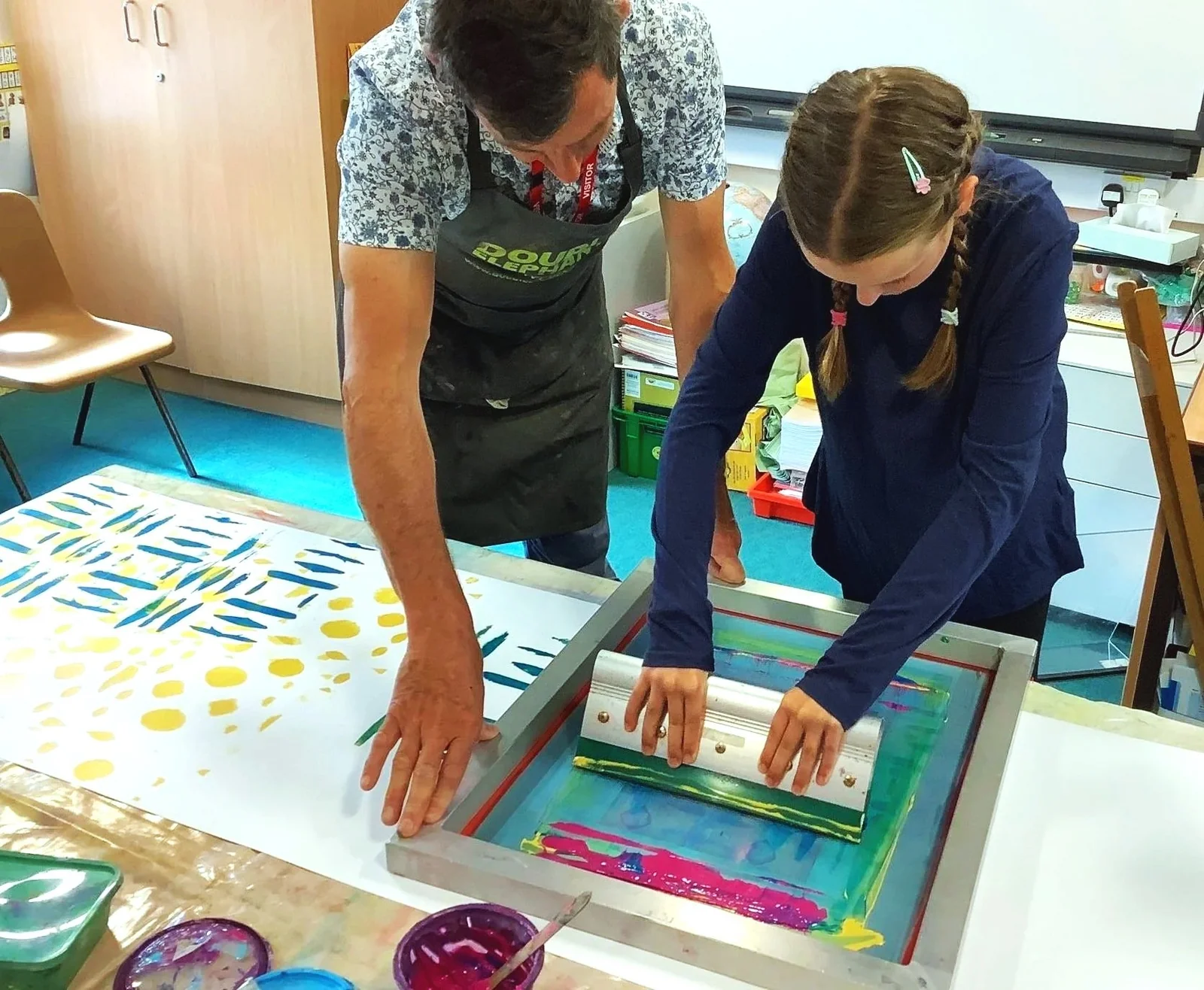 A tutor guiding a participant through screenprinting at Double Elephant