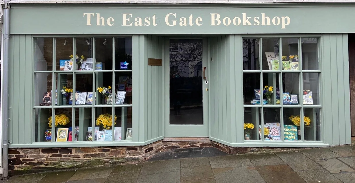 Pale green East Gate Bookshop frontage with books in both windows