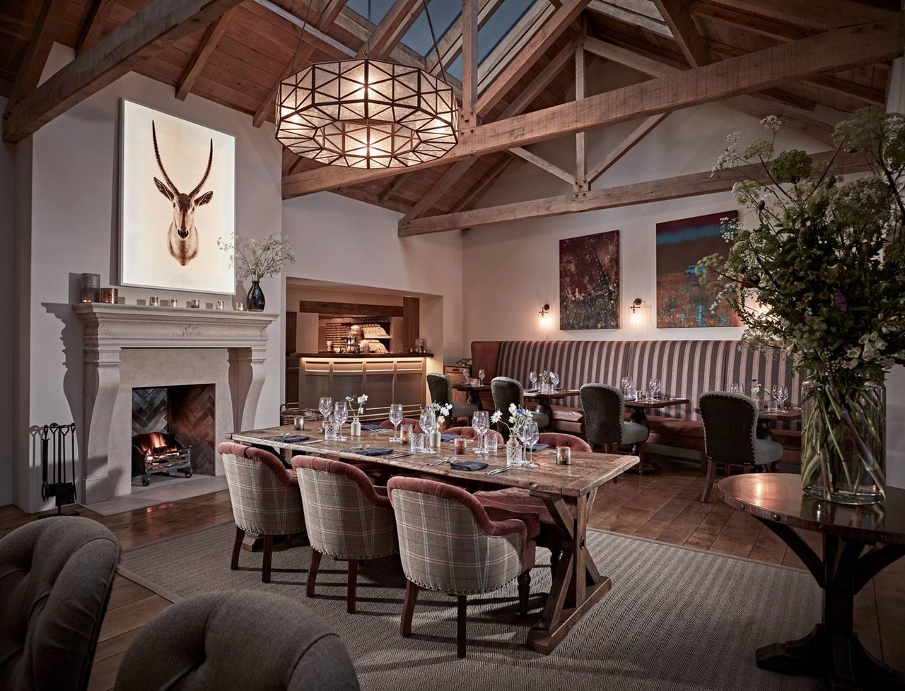 The Farmers Arms dining room with timber beams, a fireplace and upholstered chairs