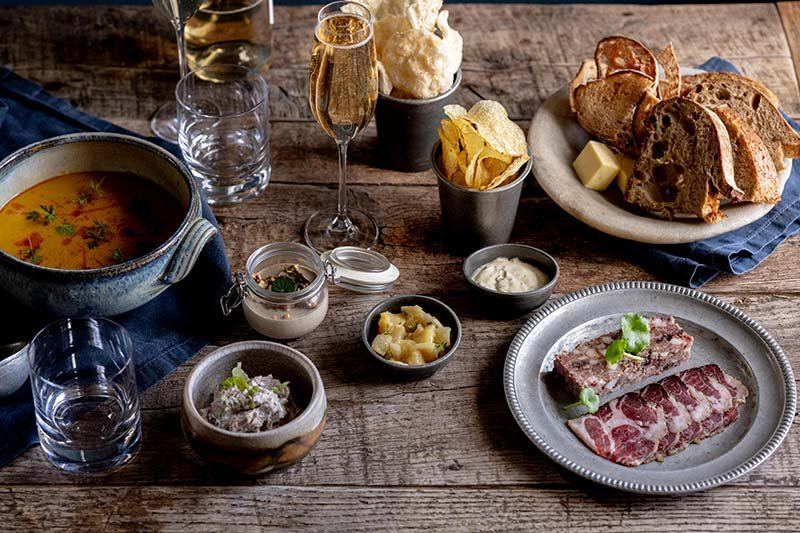 A spread of seasonal dishes and drinks on a wooden table