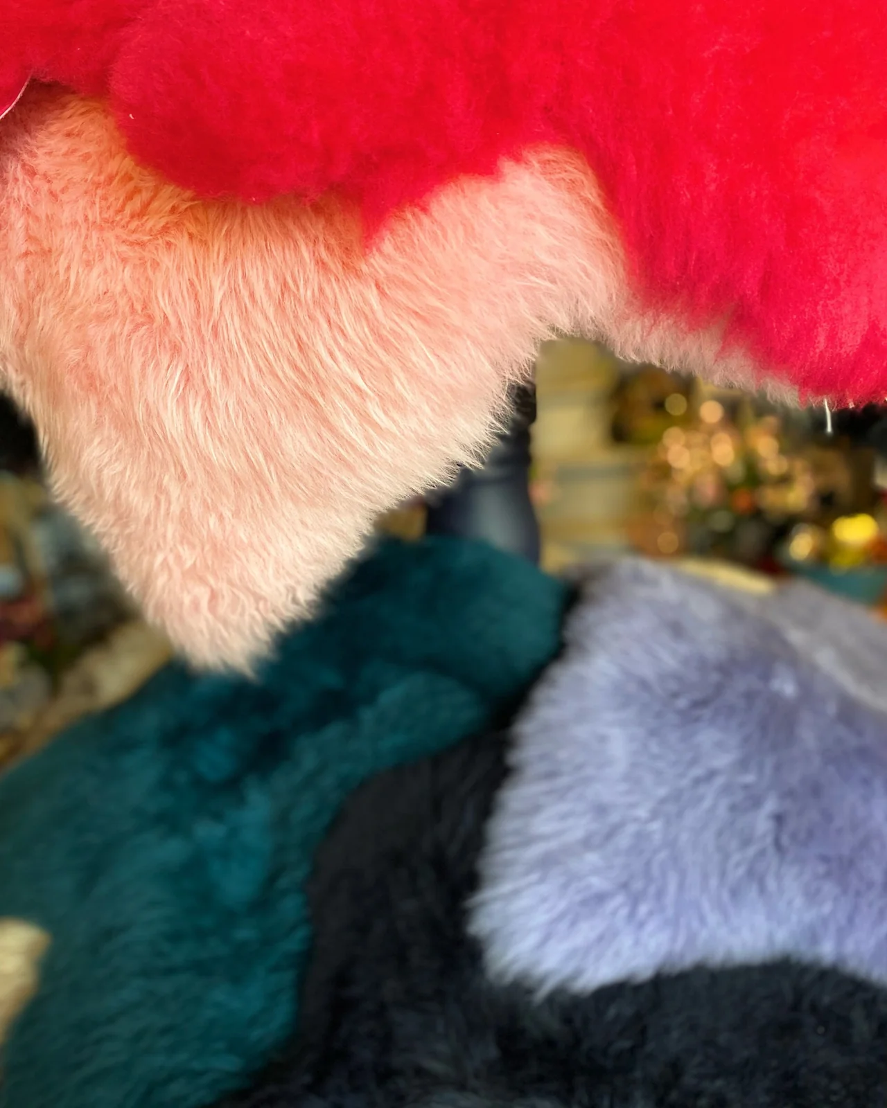 Sheepskins displayed in red, pink, teal and pale grey