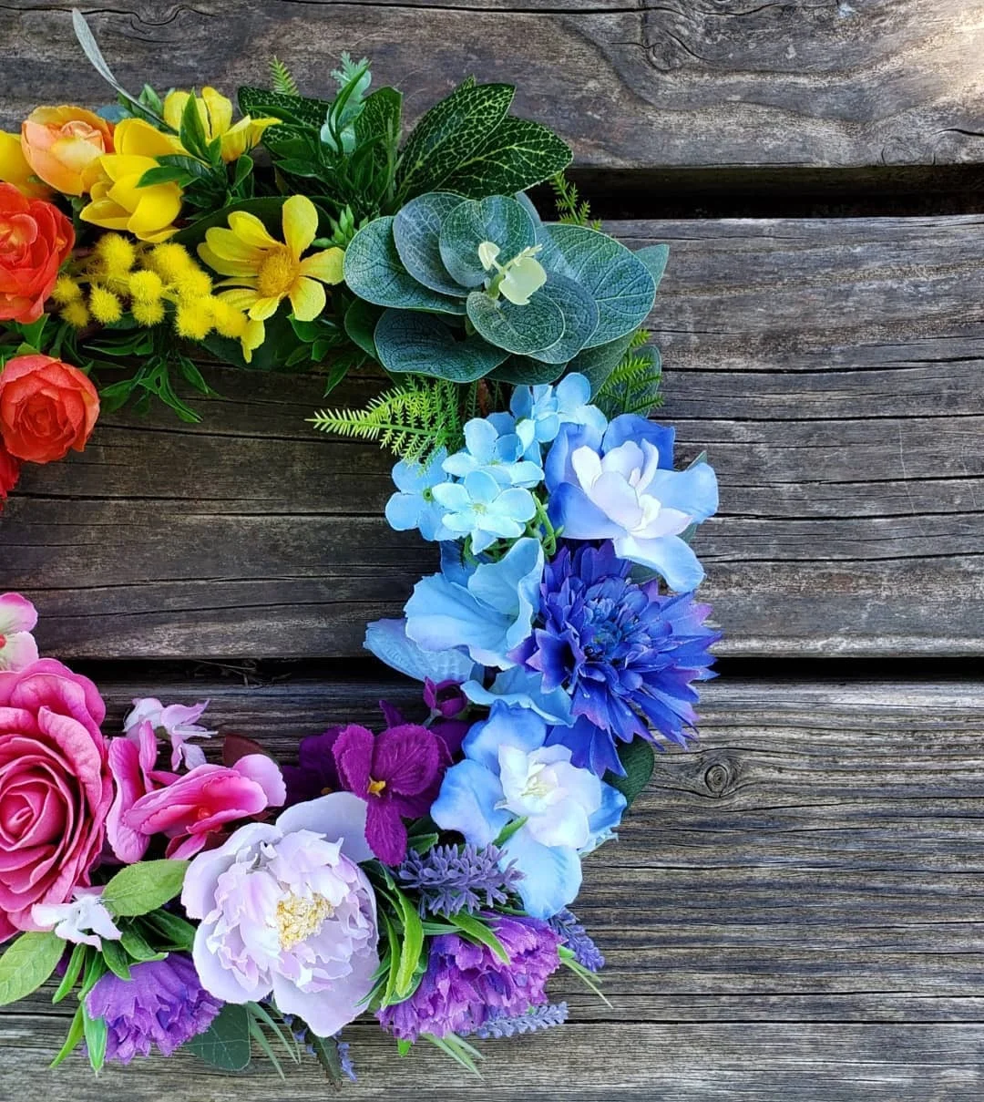 Colourful floral wreath on a timber background