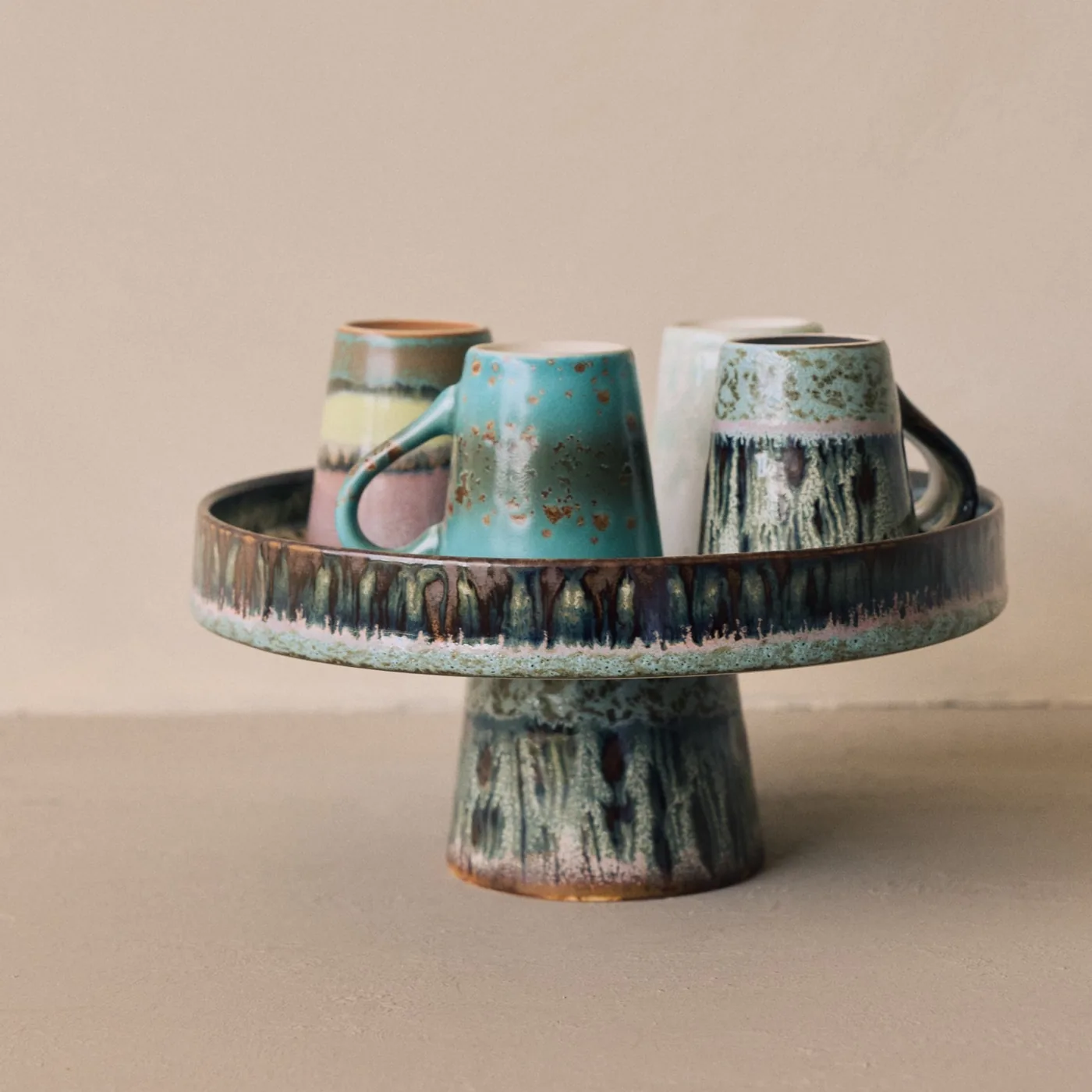 Glazed ceramic cups on a matching raised serving stand from HKLIVING
