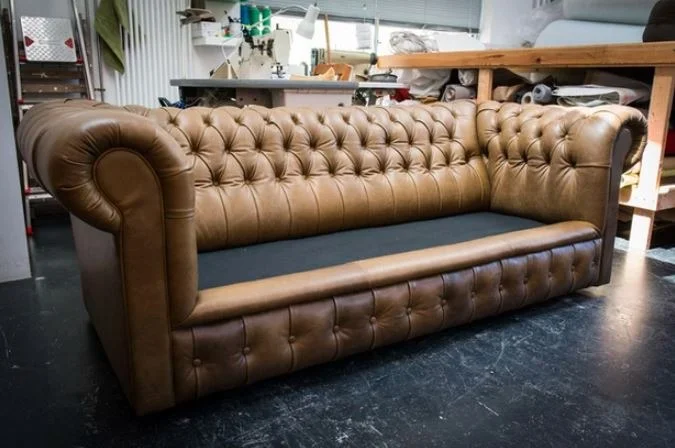 Buttoned leather Chesterfield-style sofa in a workshop setting