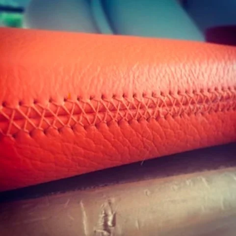 Close-up of stitching on orange leather