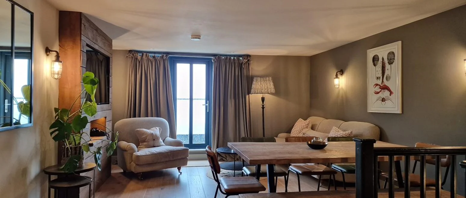 Spacious living area with sofas and sea-facing doors