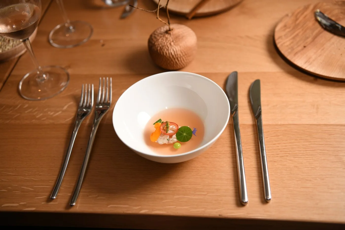 A small plated course on a wooden restaurant table