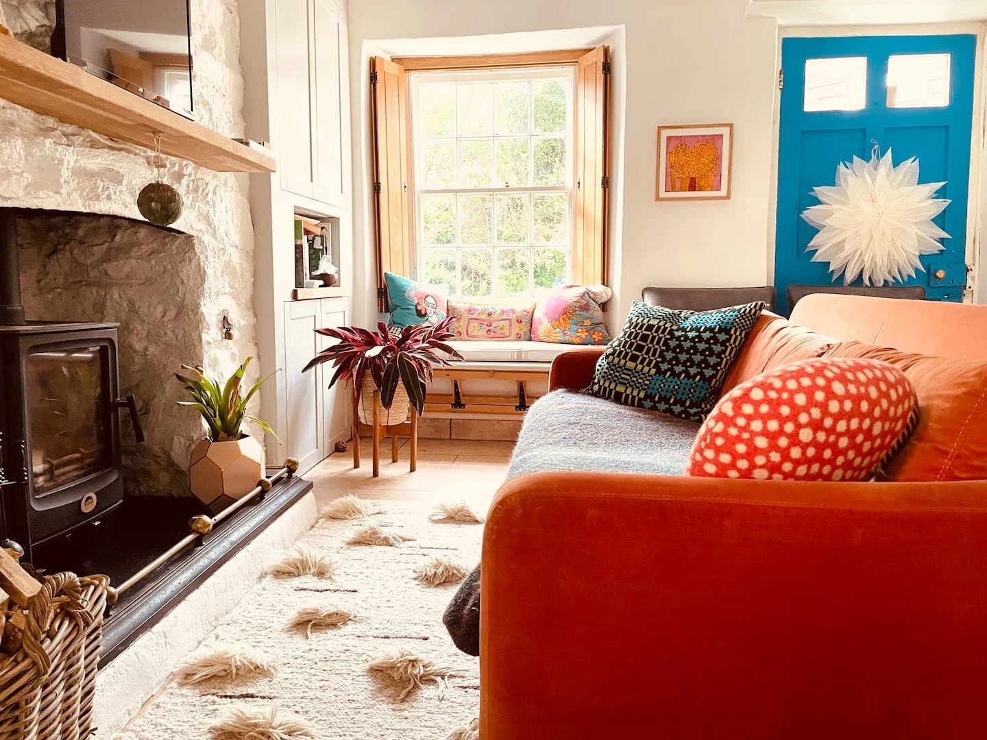 Orange sofa beside a stone fireplace
