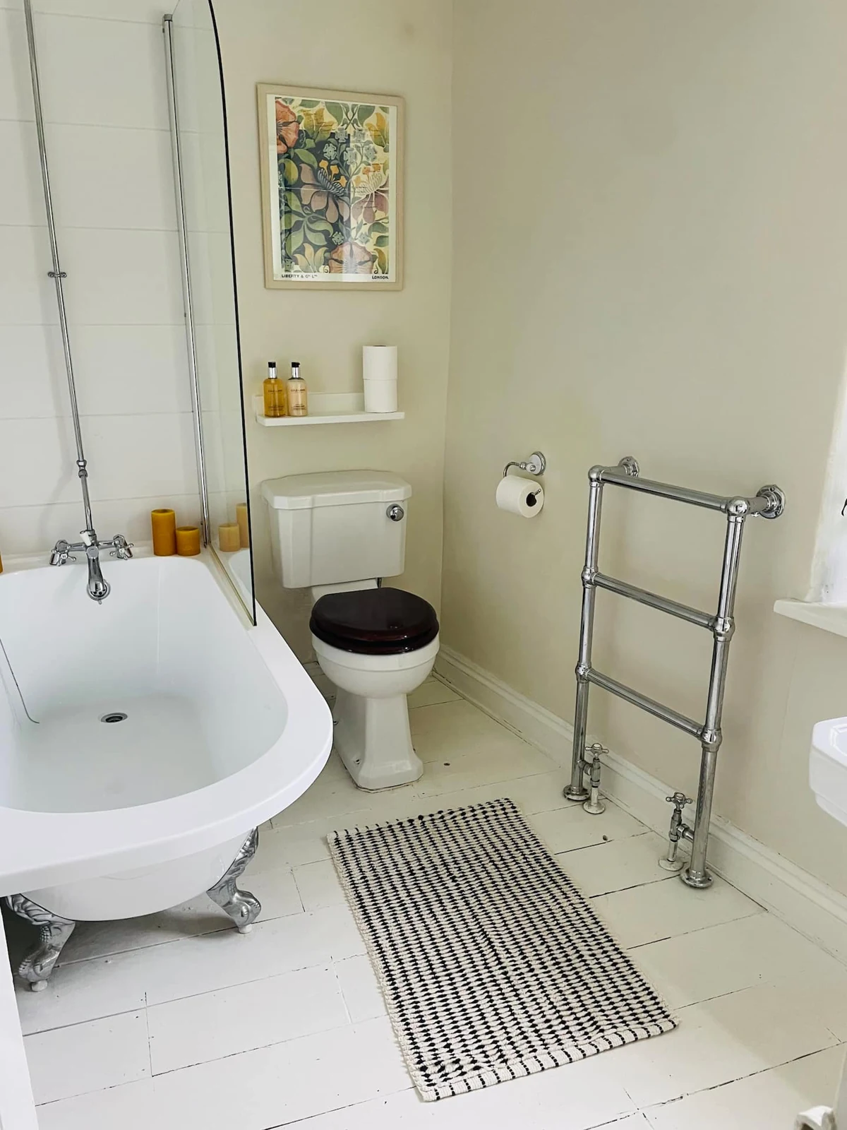 Roll-top bath beneath a framed picture