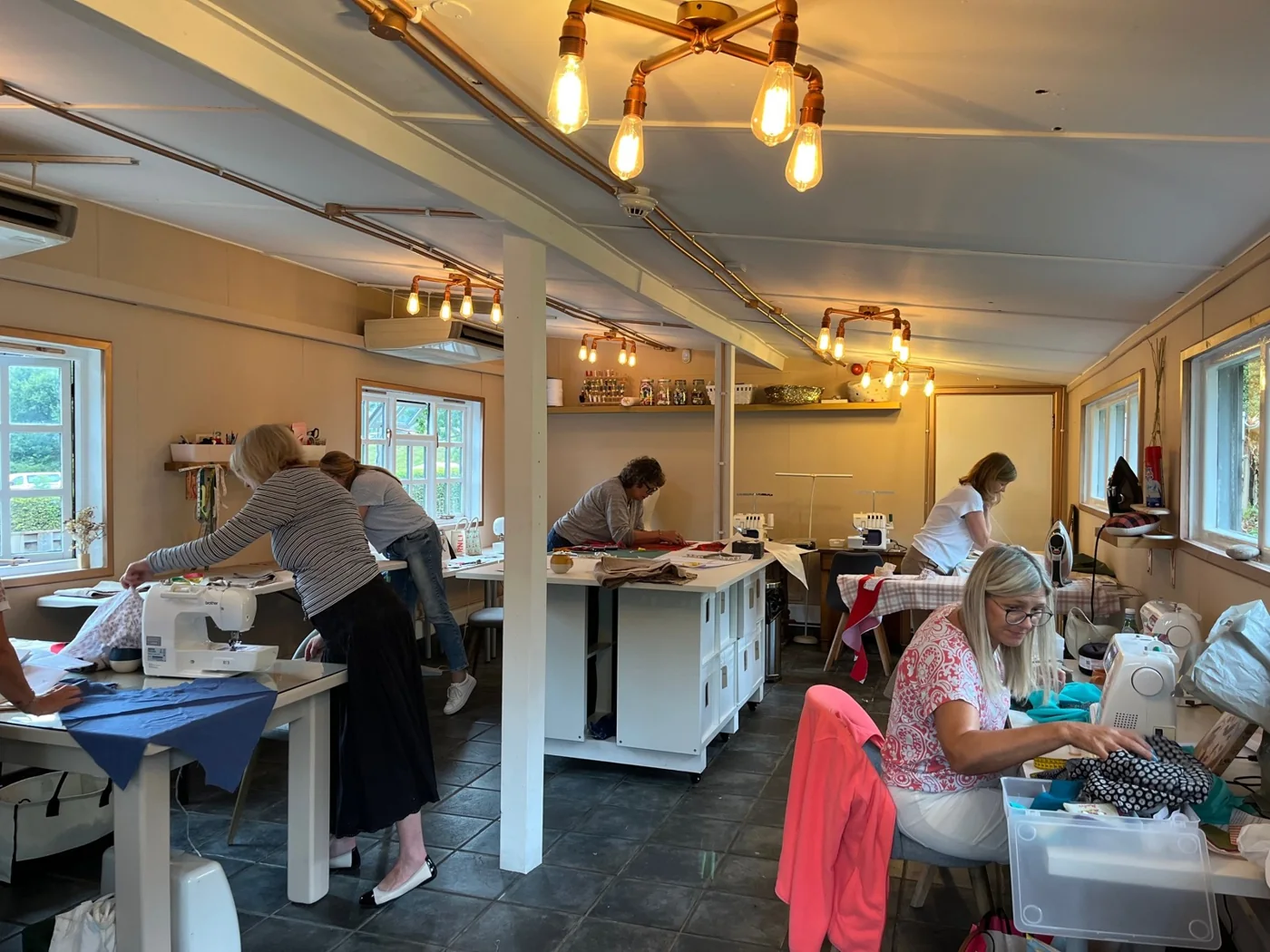 People sewing at tables in the Go Deer workshop