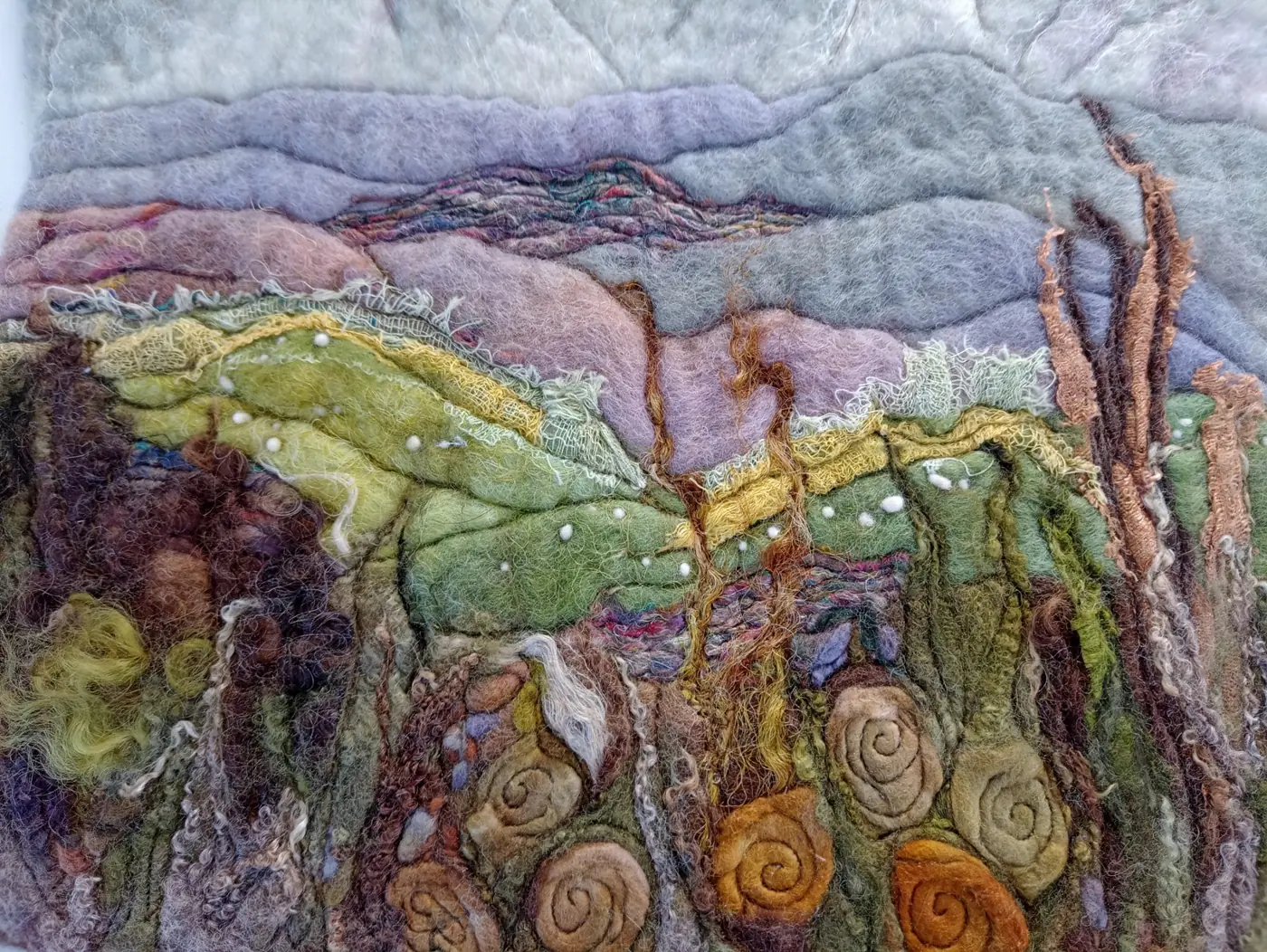A textured felt landscape with stitched details