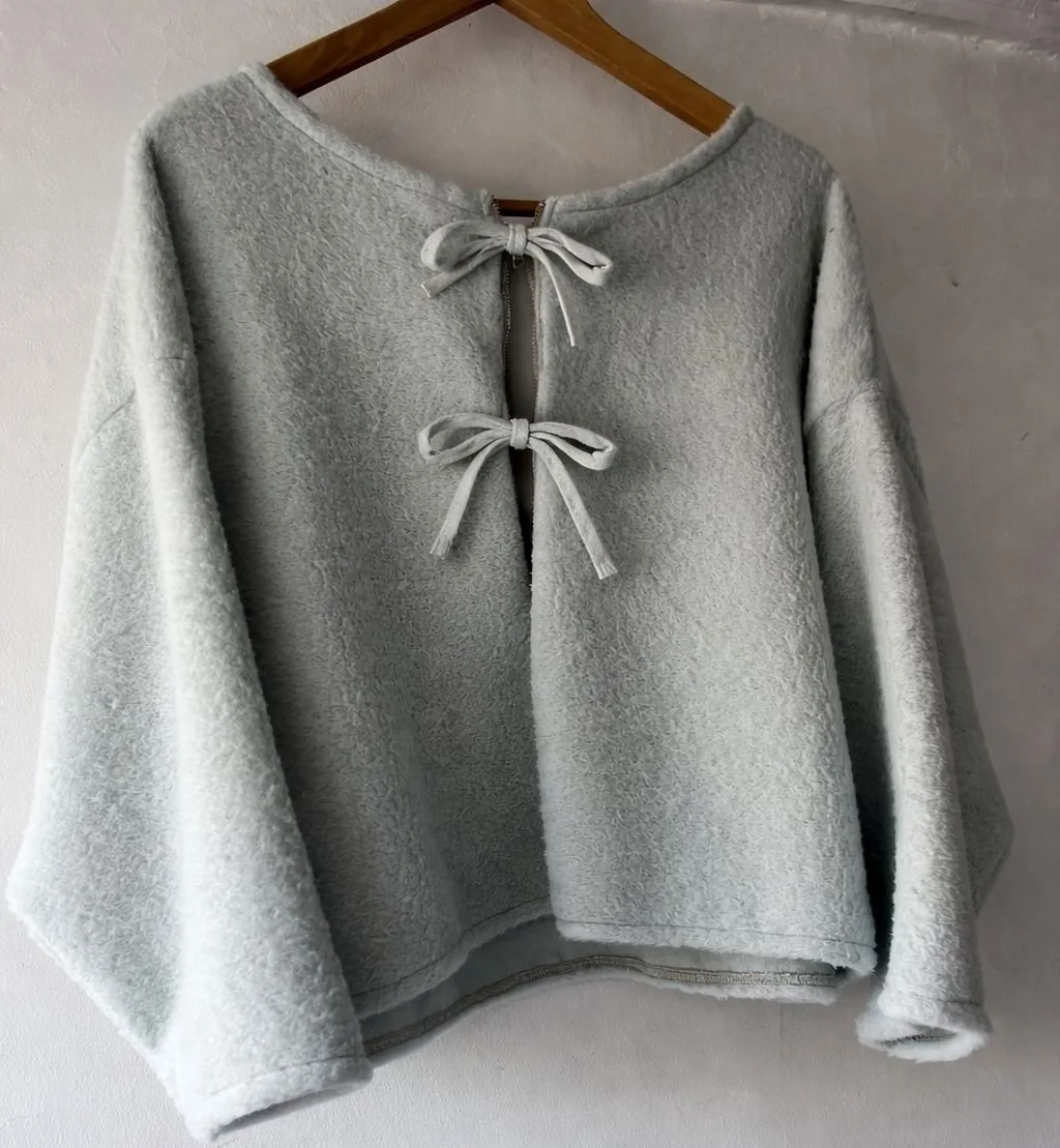 A handmade grey top with bow fastenings
