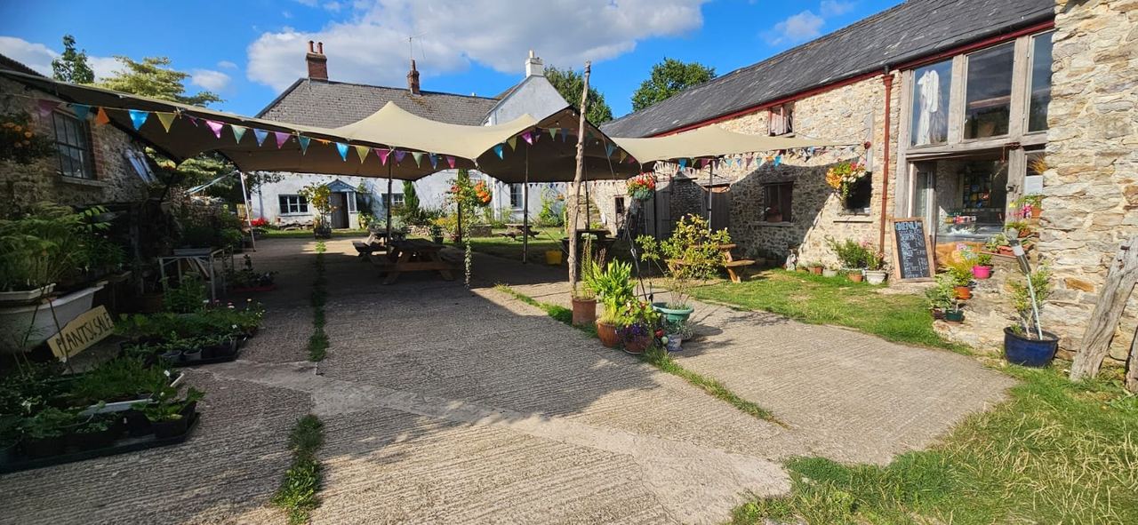 Flower-filled farm courtyard with tables and bunting at Goren