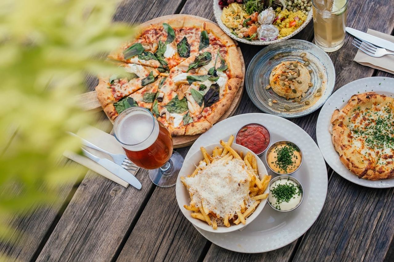 Pizza and colourful dishes on a table at The Green Table